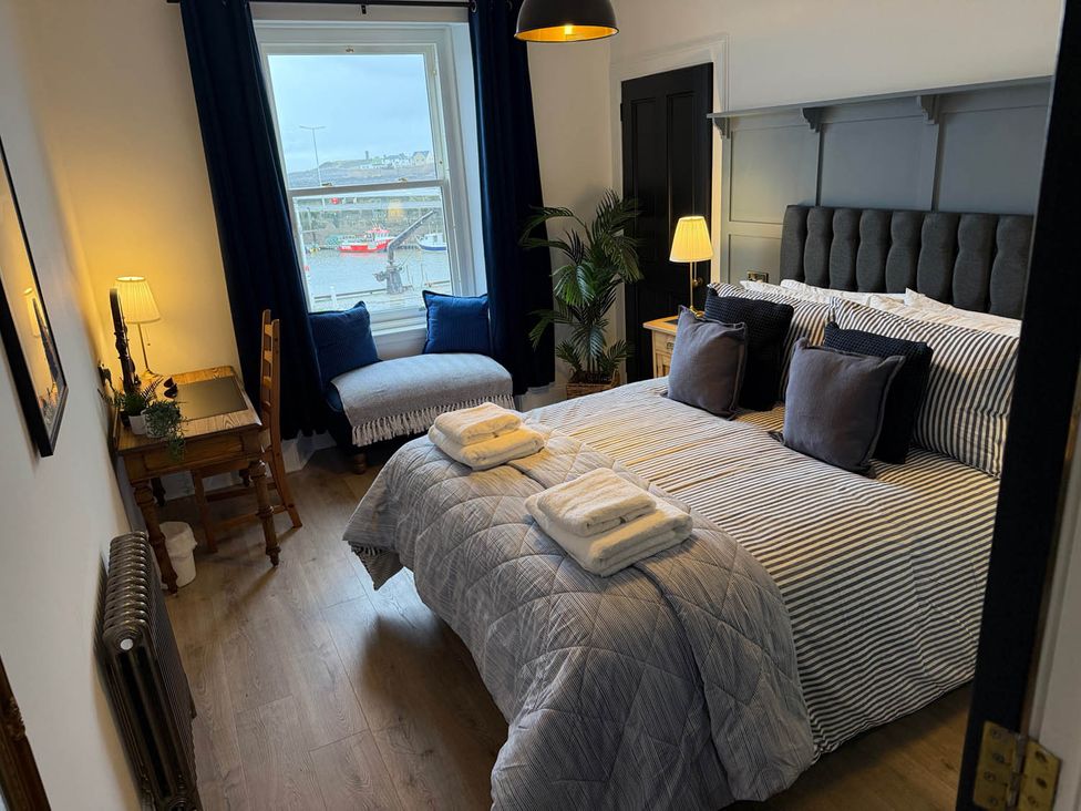 A bedroom with a bed and table at Seaview Apartment 2Bed on Anstruther Harbour, Anstruther