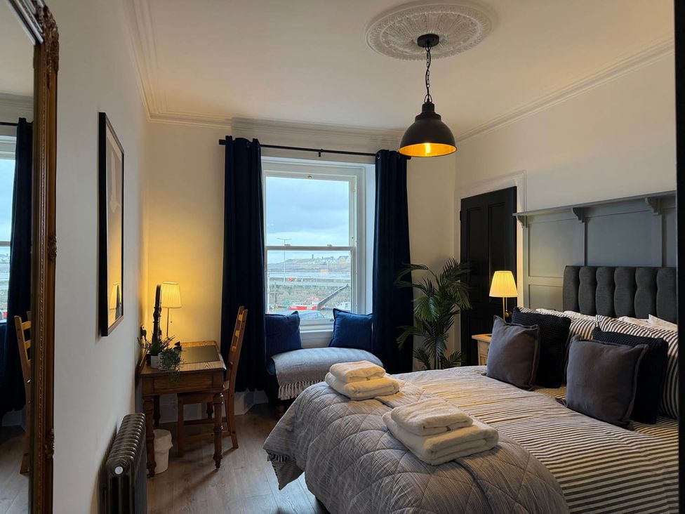 A bedroom with a bed and window view at Seaview Apartment 2Bed on Anstruther Harbour Anstruther