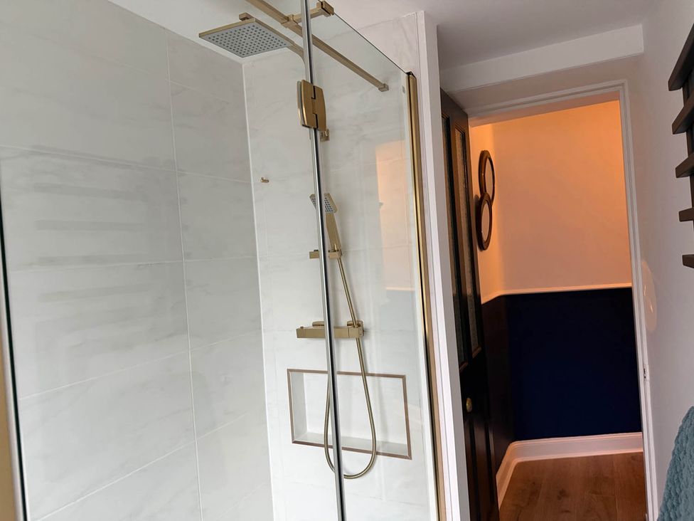 A shower with a glass enclosure and a showerhead at Seaview Apartment 2Bed on Anstruther Harbour in Anstruther