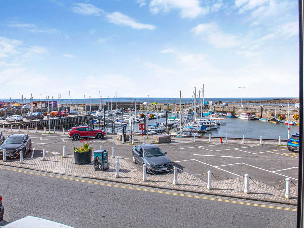 A view of a fishing harbor with parked cars at Seaview Apartment 2Bed on Anstruther Harbour Anstruther