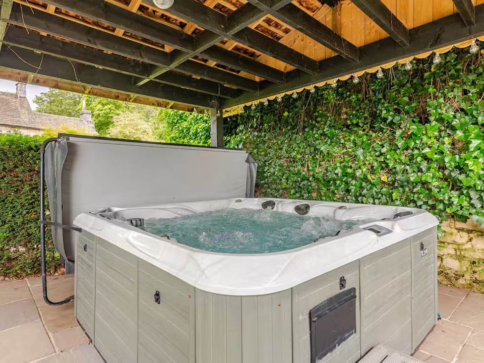 A hot tub under a shelter in an outdoor area at Dowgill 3Bed Barn Sleeps 7 Hot Tub Parking Near Summerbridge