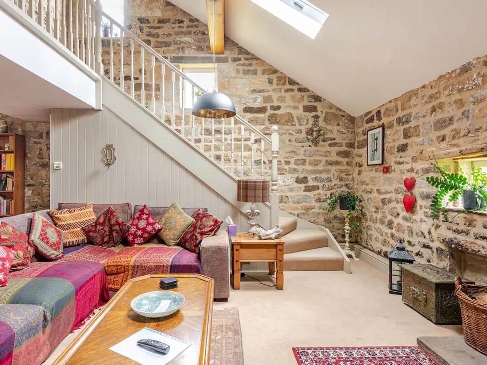 A living room with a sofa and stairs at Dowgill 3Bed Barn Sleeps 7 Hot Tub Parking Near Summerbridge