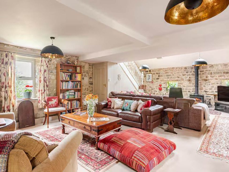 A living room with a sofa, coffee table, and bookshelves at Dowgill 3Bed Barn Sleeps 7 Hot Tub Parking Near Summerbridge