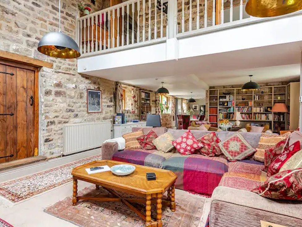 A living room with a sofa and bookshelves at Dowgill 3Bed Barn Sleeps 7 Hot Tub Parking Near Summerbridge