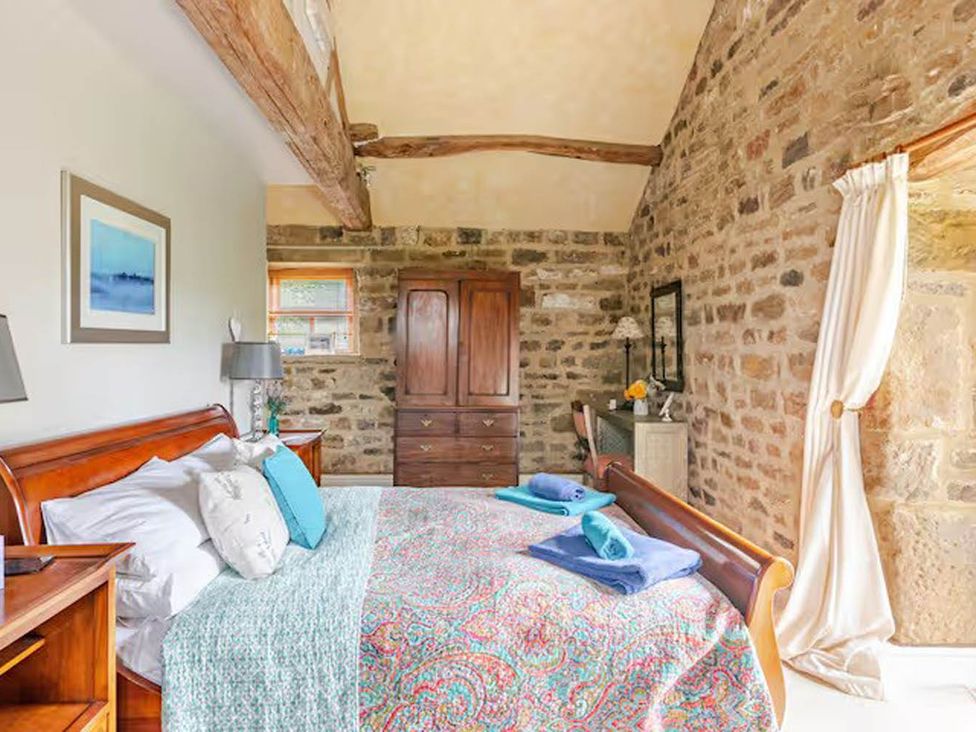 A bedroom with a bed and dresser at Dowgill 3Bed Barn Sleeps 7 Hot Tub Parking near Summerbridge
