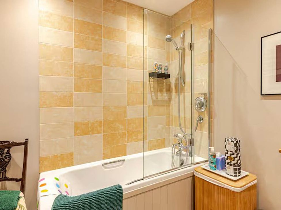 A bathroom with a bathtub and shower at Dowgill 3Bed Barn Sleeps 7 Hot Tub Parking Near Summerbridge