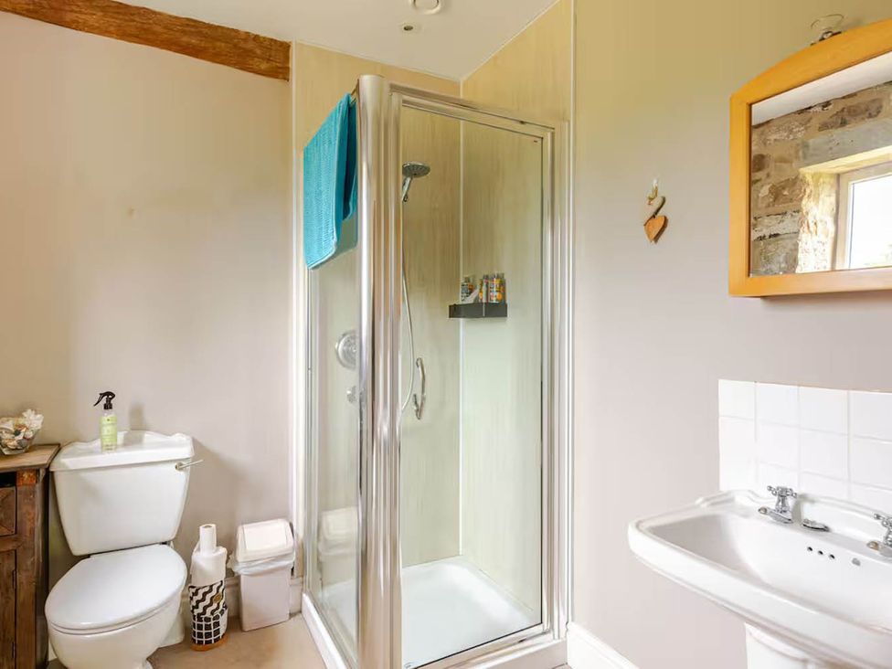 A bathroom with a shower, sink, toilet, and mirror at Dowgill 3Bed Barn Sleeps 7 Hot Tub Parking near Summerbridge