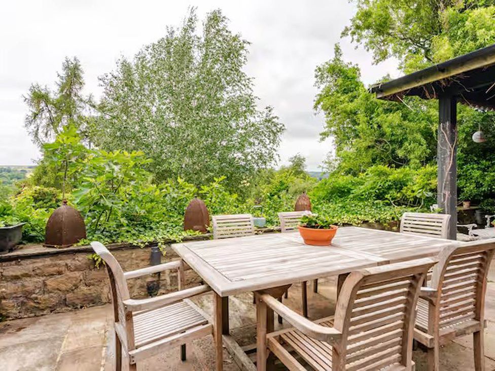 A garden with a wooden table and chairs at Dowgill 3Bed Barn Sleeps 7 Hot Tub Parking Near Summerbridge