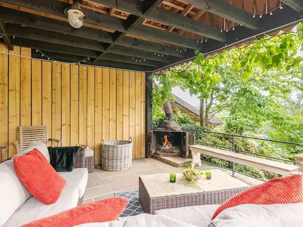 An outdoor living area with seating and fireplace at Dowgill 3Bed Barn Sleeps 7 Hot Tub Parking Near Summerbridge