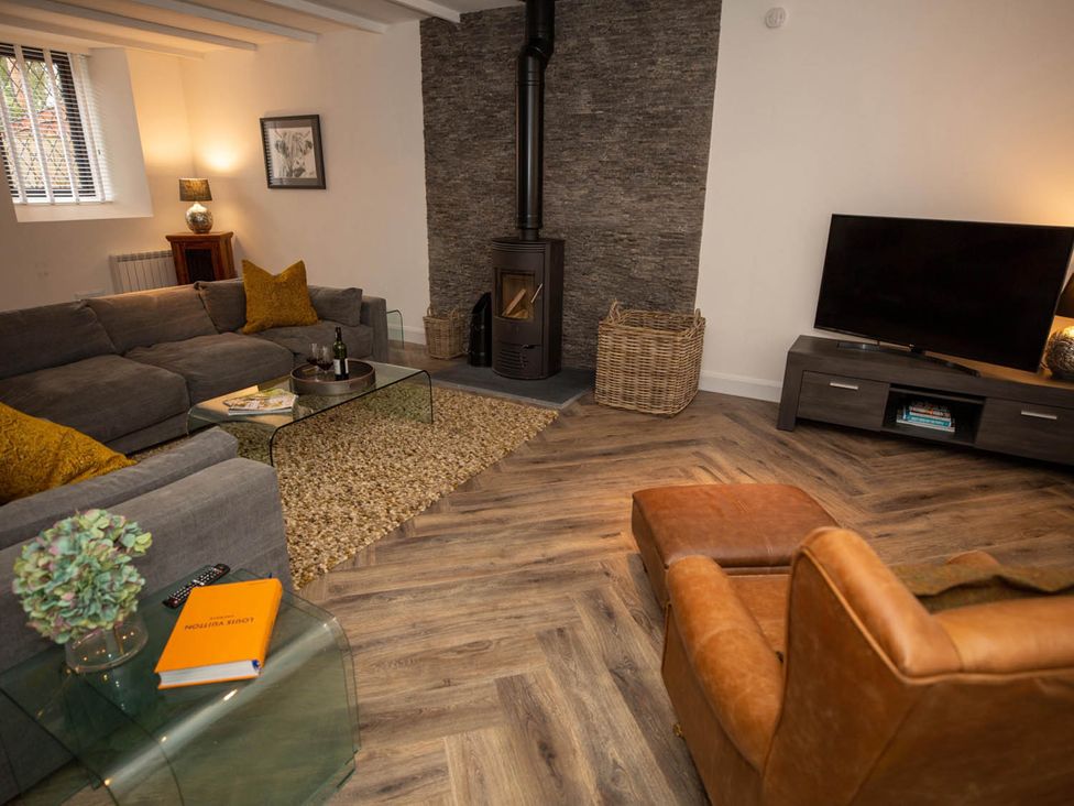 A living room with a sofa and fireplace at Stunning 3 Bed Converted Village Hall Near Kelso in Nenthorn near Kelso