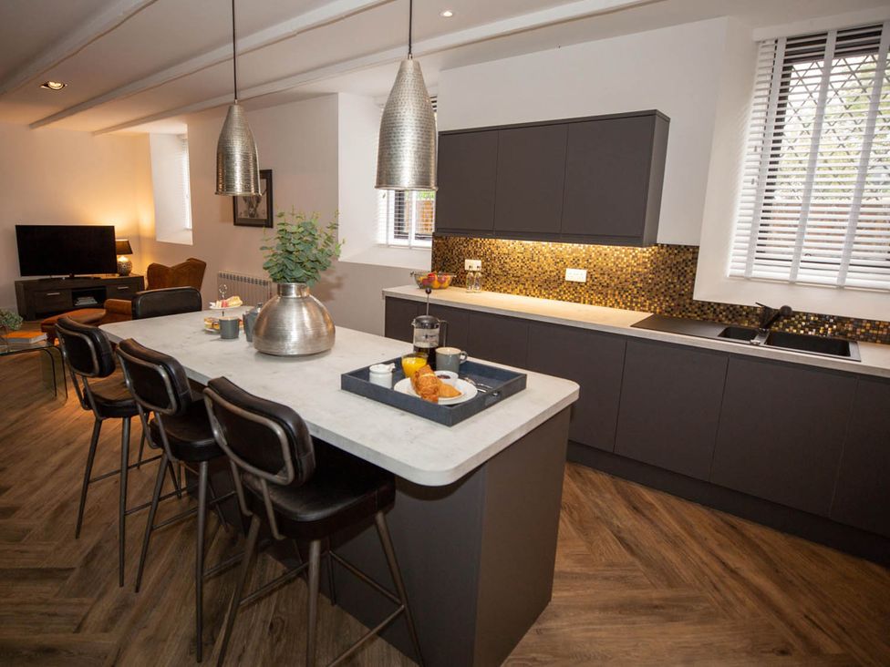 A kitchen with bar stools and countertop at Stunning 3 Bed Converted Village Hall Near Kelso