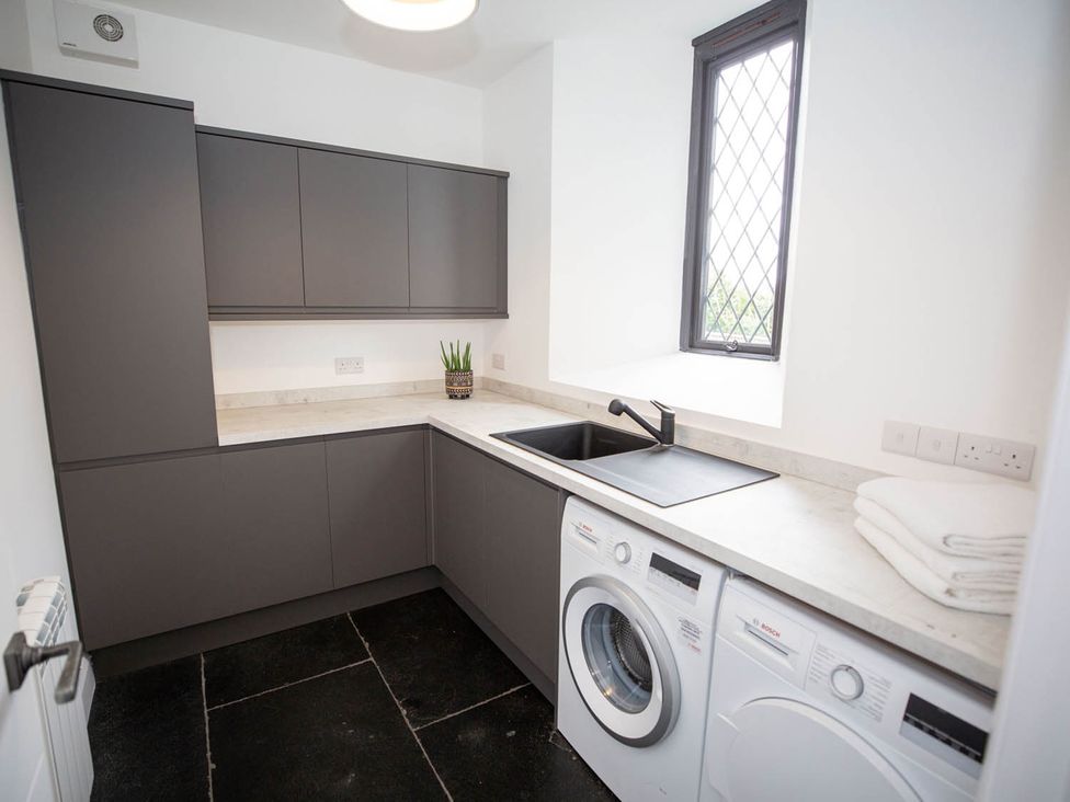 A utility room with a washing machine and sink at Stunning 3 Bed Converted Village Hall Near Kelso Nenthorn near Kelso