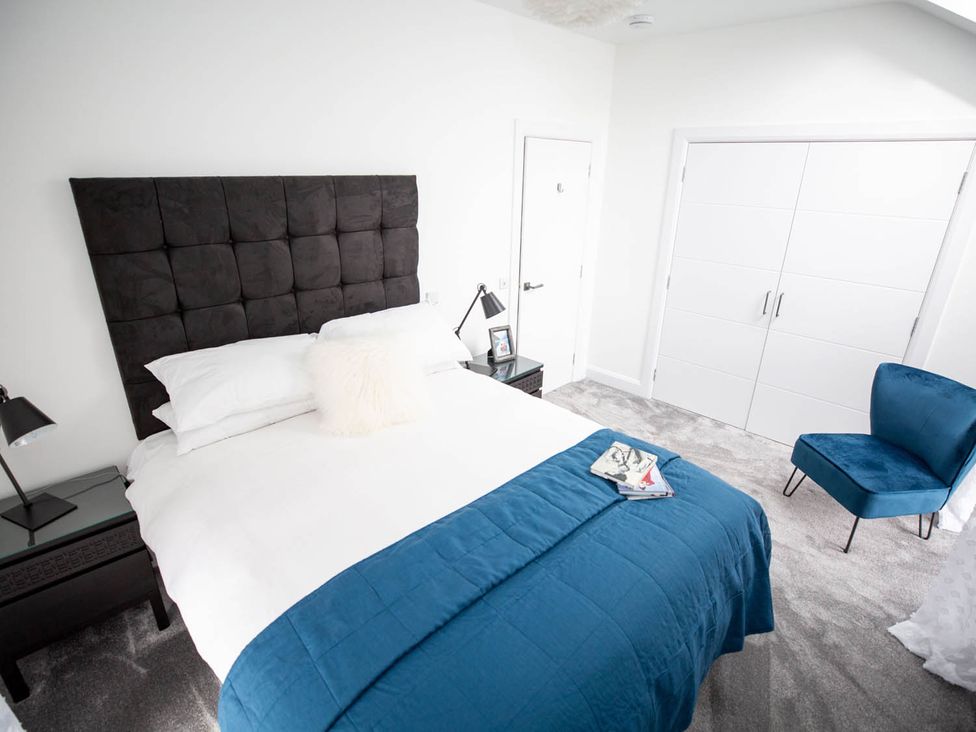 A bedroom with a bed and bedside table at Stunning 3 Bed Converted Village Hall Near Kelso
