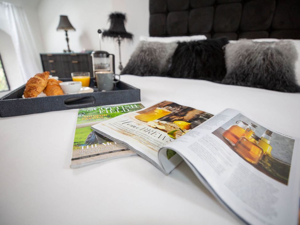 A breakfast tray with croissants and coffee in a bedroom at Stunning 3 Bed Converted Village Hall Near Kelso