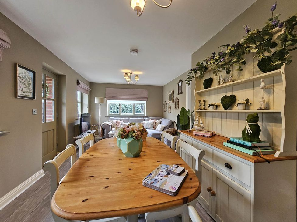 A dining room with a wooden table and shelves at Cottage Sleep 4 Pet Friendly Enclosed Garden, Rollesby, near Scratby