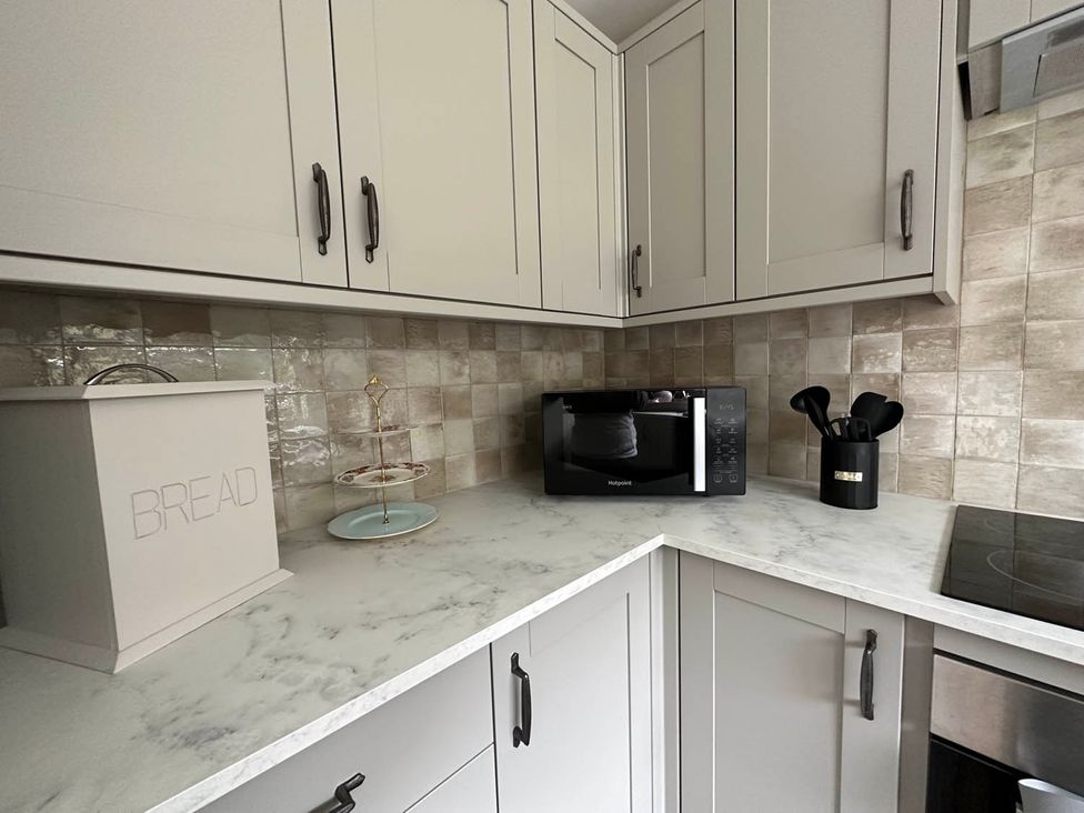 A kitchen with a microwave and bread box at Cottage Sleep 4 Pet Friendly Enclosed Garden in Rollesby, near Scratby