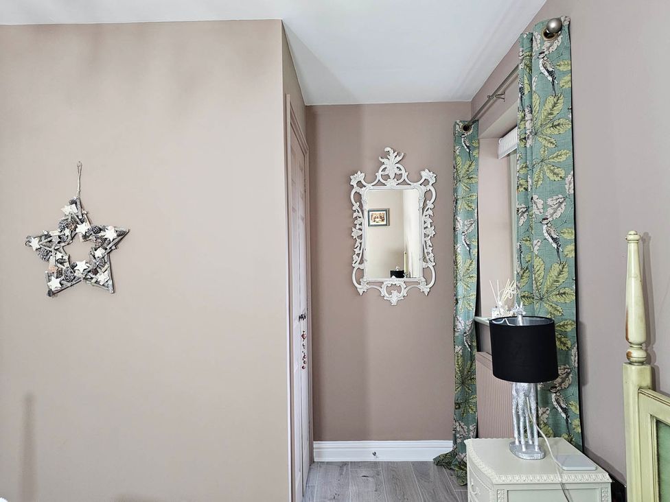 A bedroom with a mirror and lamp at Cottage Sleep 4 Pet Friendly Enclosed Garden, Rollesby, near Scratby