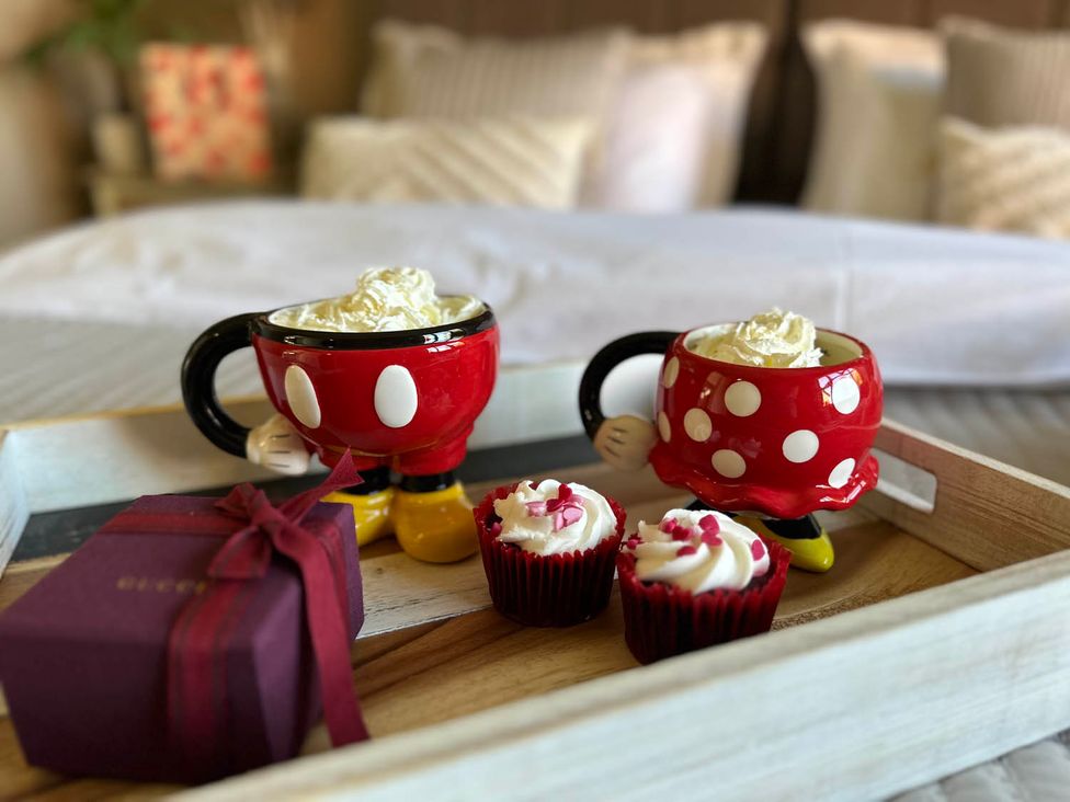 A serving tray with mugs and cupcakes in a bedroom at Cottage Sleep 4 Pet Friendly Enclosed Garden in Rollesby, near Scratby