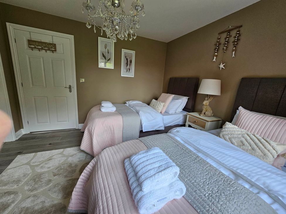 A bedroom with two beds and a chandelier at Cottage Sleep 4 Pet Friendly Enclosed Garden in Rollesby, near Scratby