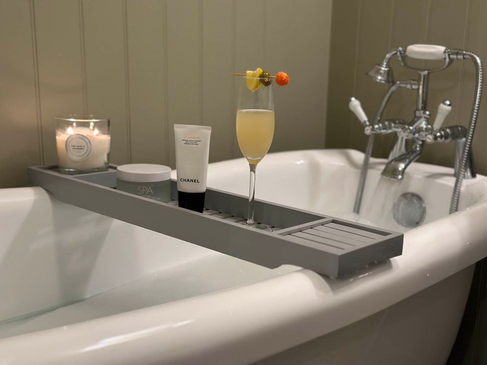 A bathroom with a bathtub and accessories at Cottage Sleep 4 Pet Friendly Enclosed Garden, Rollesby, near Scratby