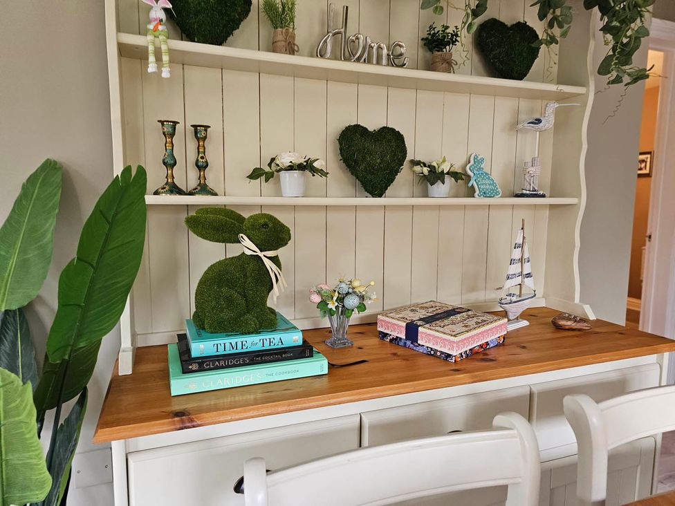 A shelf with decorative items and books at Cottage Sleep 4 Pet Friendly Enclosed Garden Rollesby, near Scratby