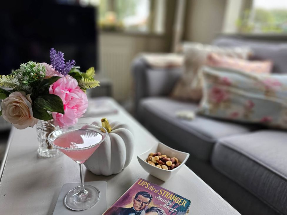 A coffee table with a cocktail and snacks in the living room at Cottage Sleep 4 Pet Friendly Enclosed Garden Rollesby, near Scratby