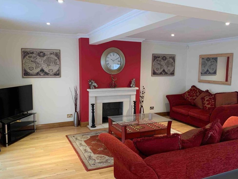 A living room with a sofa and television at 2Bedroom Cottage with 2 Ensuites Sleeps 6 Wifi Near Rye