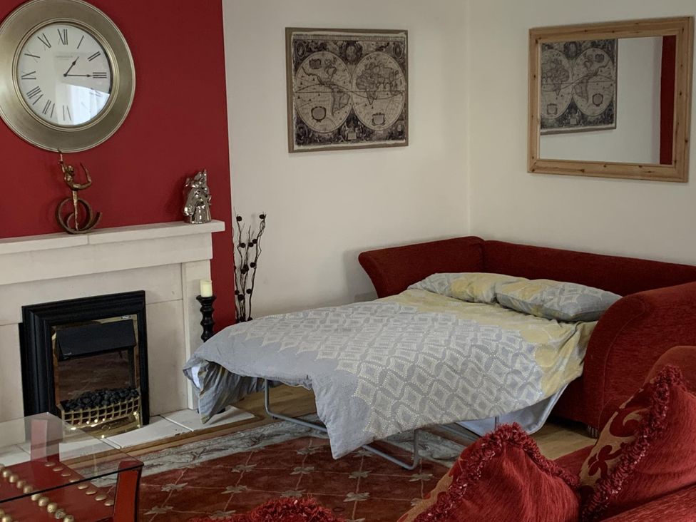 A living room with a sofa and a fireplace at 2Bedroom Cottage with 2 Ensuites Sleeps 6 Wifi Near Rye