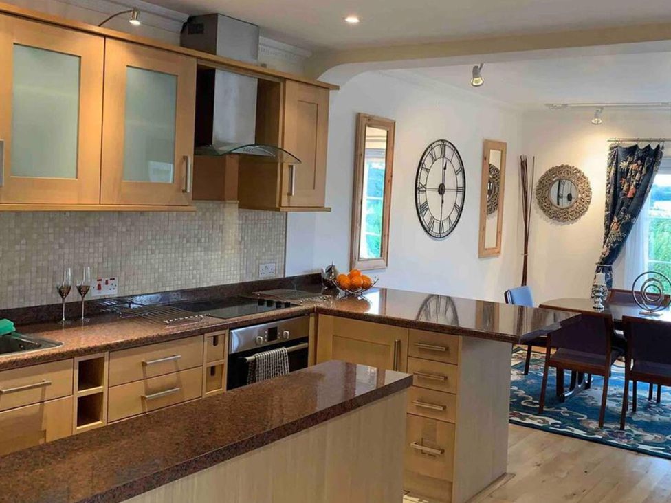 A kitchen with cabinets and dining area at 2Bedroom Cottage with 2 Ensuites Sleeps 6 Wifi Near Rye