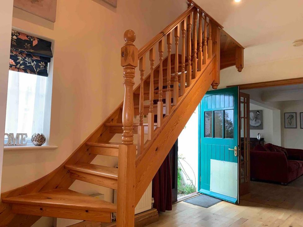 A hallway with a staircase and an open door at 2Bedroom Cottage with 2 Ensuites Sleeps 6 Wifi Near Rye
