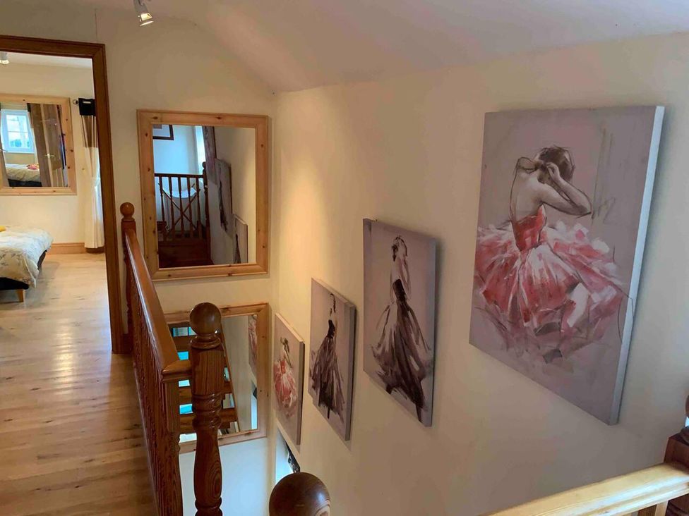 A hallway with paintings and mirrors at 2Bedroom Cottage with 2 Ensuites Sleeps 6 Wifi Near Rye