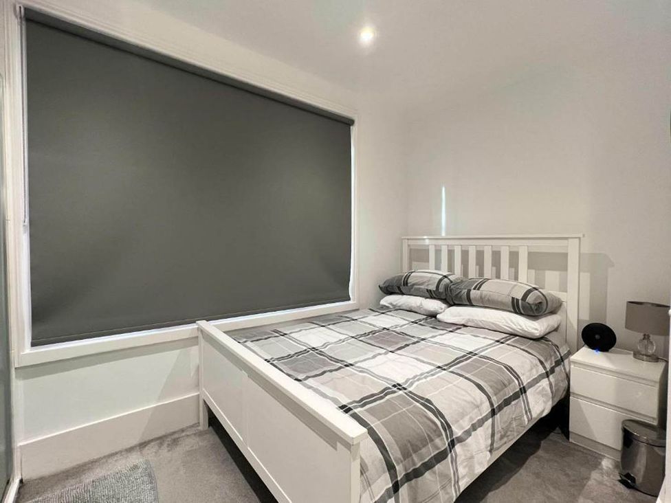 A bedroom with a bed and bedside table at Family Friendly Apt Sleeps 6 Station Close in Royal Tunbridge Wells