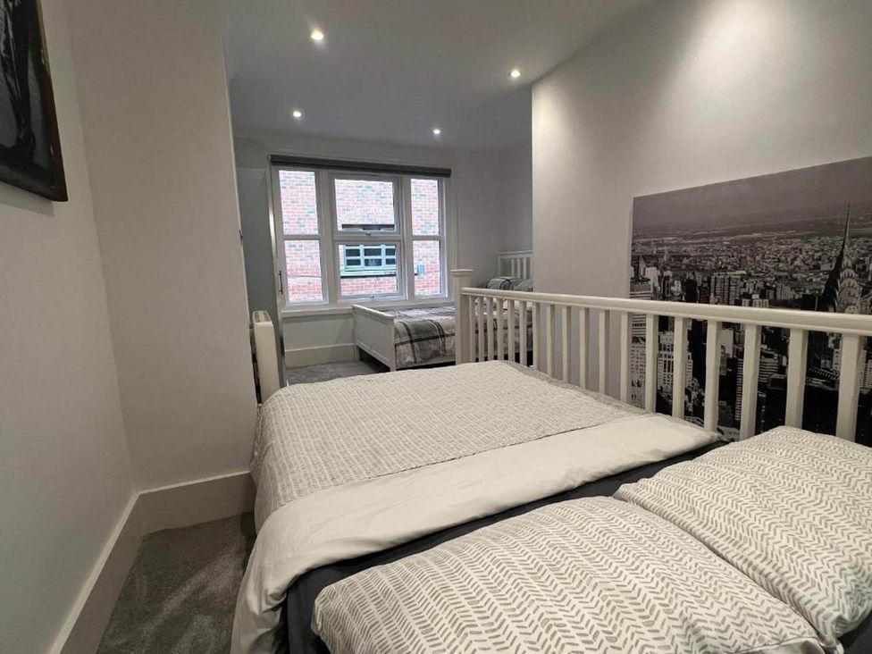 A bedroom with two beds and windows at Family Friendly Apt Sleeps 6 Station Close in Royal Tunbridge Wells