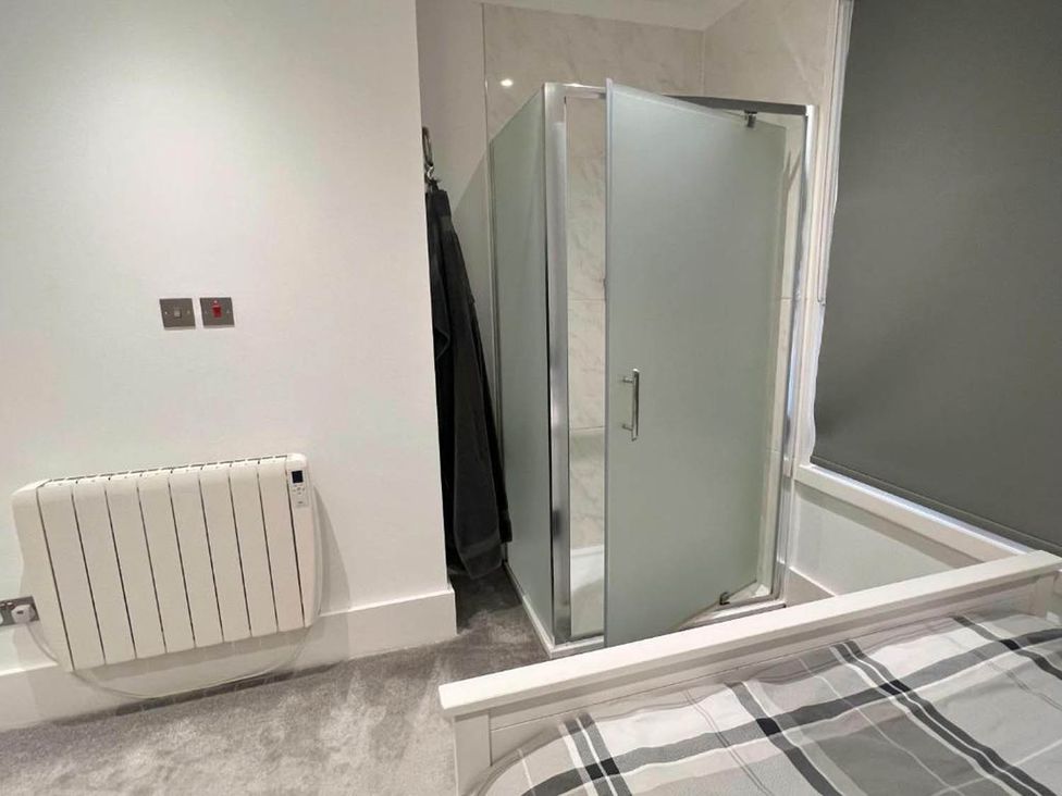 A bedroom with a shower in the corner at Family Friendly Apt Sleeps 6 Station Close Royal Tunbridge Wells