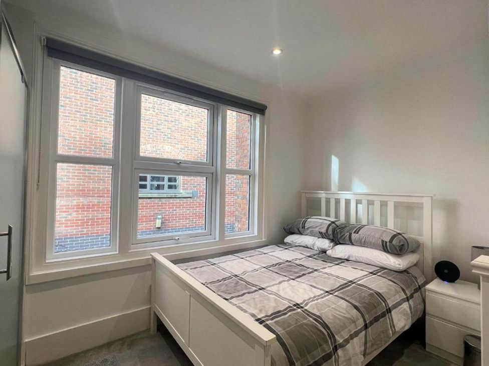 A bedroom with a bed and windows at Family Friendly Apt Sleeps 6 Station Close Royal Tunbridge Wells