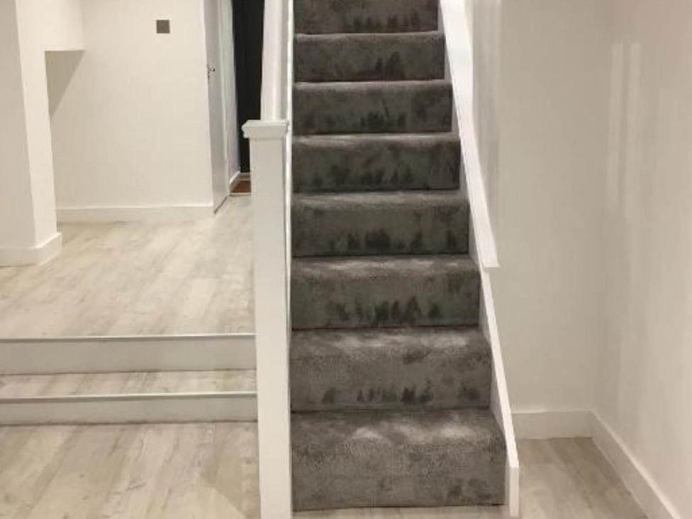 A staircase with carpet and a handrail at Family Friendly Apt Sleeps 6 Station Close Royal Tunbridge Wells