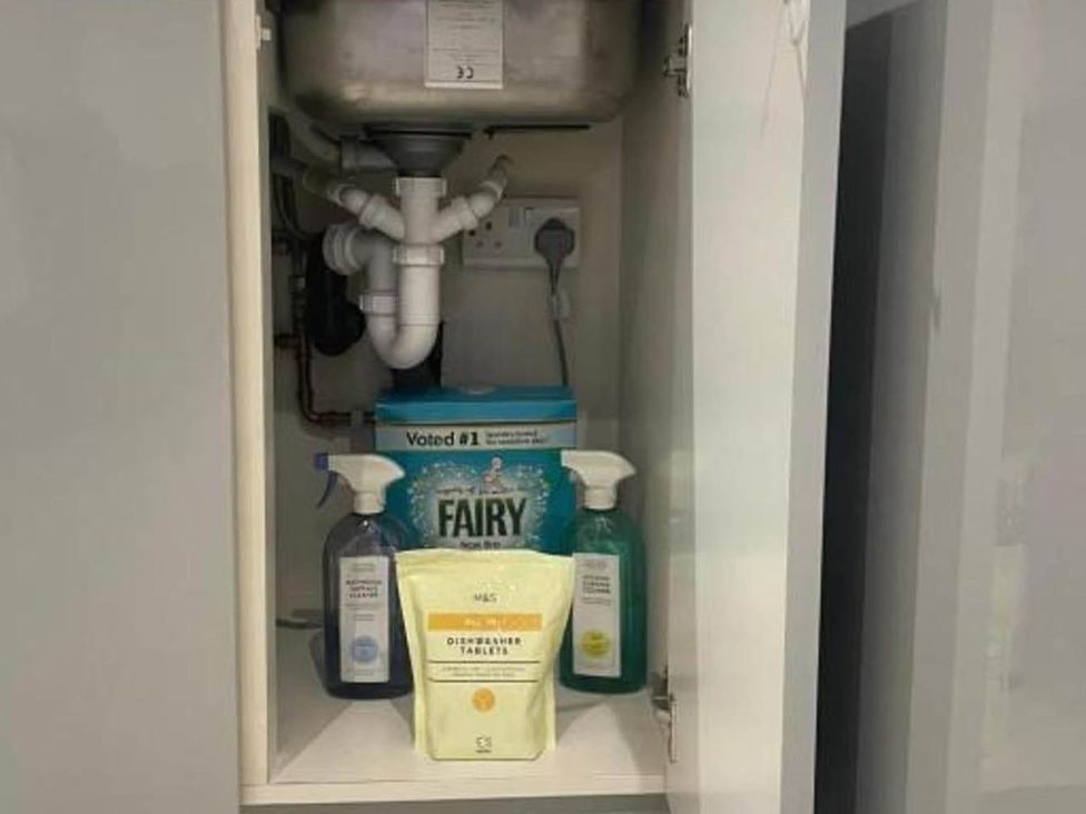 A cabinet with cleaning supplies and plumbing under the sink at Family Friendly Apt Sleeps 6 Station Close Royal Tunbridge Wells