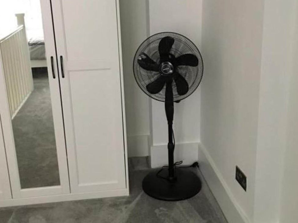 A bedroom with a fan next to a wardrobe at Family Friendly Apt Sleeps 6 Station Close Royal Tunbridge Wells
