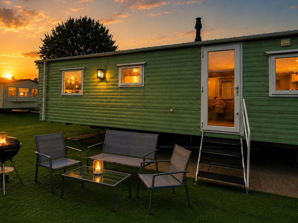 An outdoor seating area with a caravan and chairs at Billing Aquadrome Holiday Park 2bed Caravan Northampton