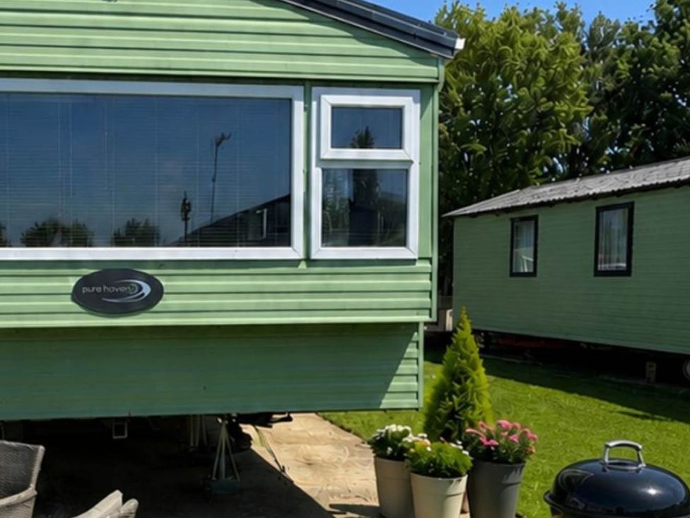 A caravan with plants in pots and grill at Billing Aquadrome Holiday Park 2bed Caravan Northampton