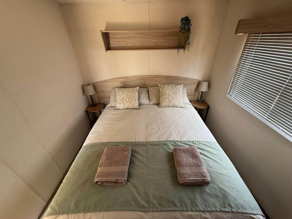 A bedroom with a bed and bedside tables at Billing Aquadrome Holiday Park 2bed Caravan Northampton