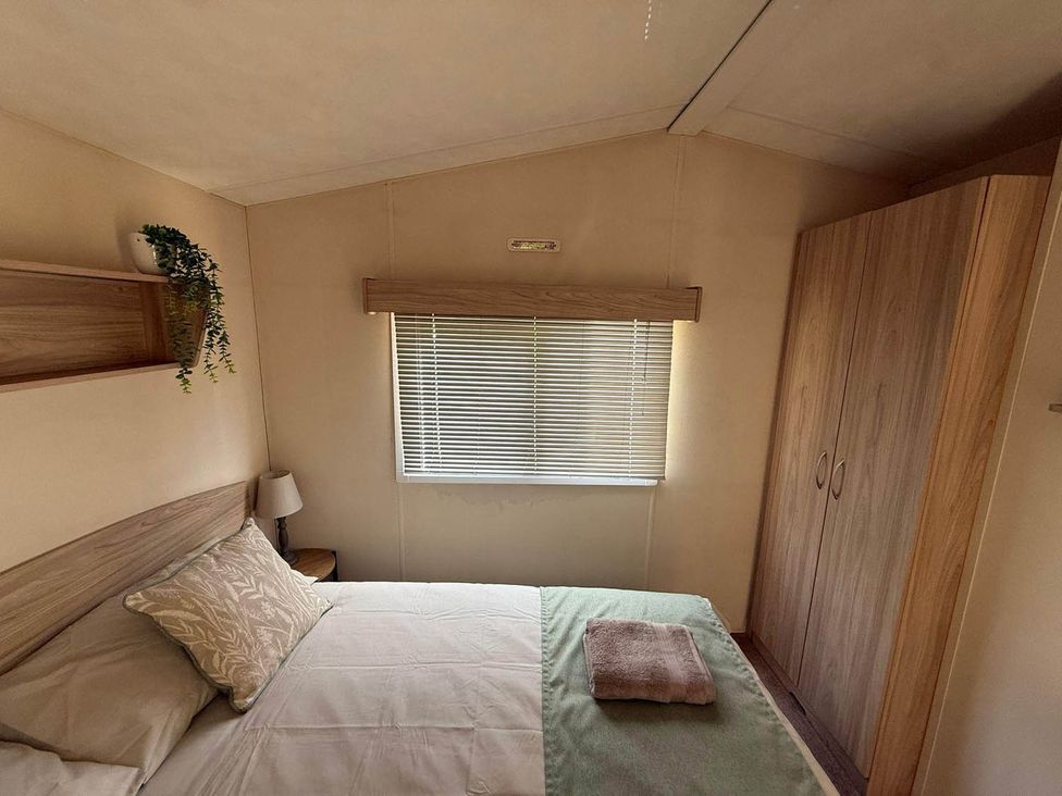 A bedroom with bed and wardrobe at Billing Aquadrome Holiday Park 2bed Caravan Northampton