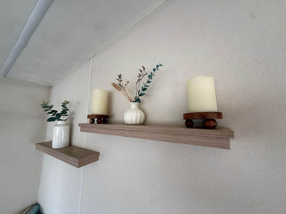A shelf with candles and a vase at Billing Aquadrome Holiday Park 2bed Caravan Northampton