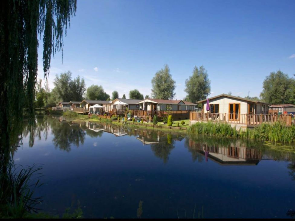 An outdoor area with caravans along a water body at Billing Aquadrome Holiday Park 2bed Caravan Northampton