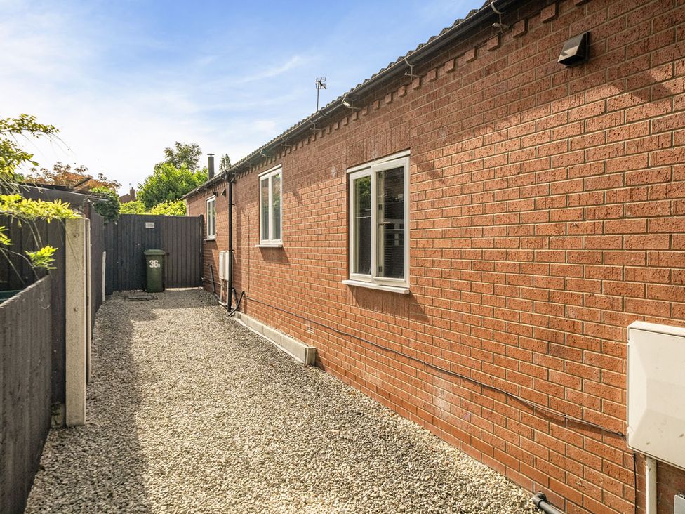 A garden area with gravel pathway and brick wall at Cozy Cottage sleeps 4 in Barton upon Humber