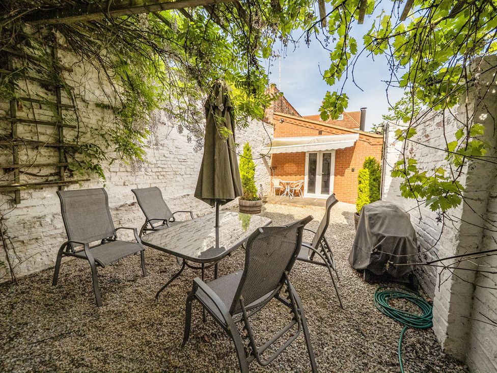 A garden with a table, chairs, and grill at Cozy Cottage sleeps 4 in Barton upon Humber
