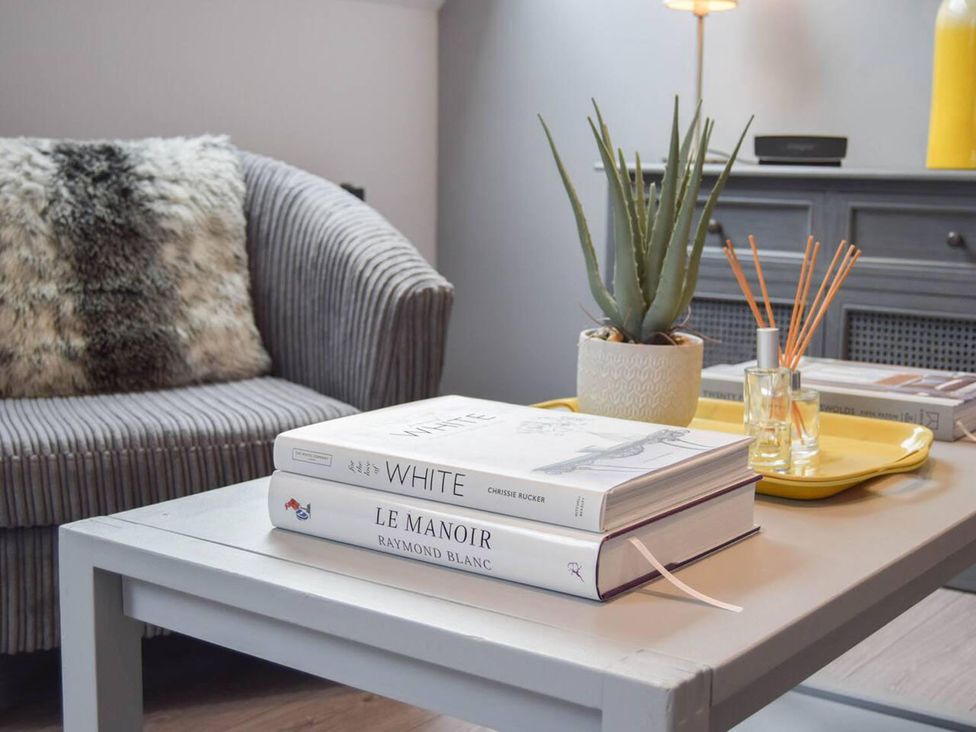 A living room with a sofa and books on a table at 1bed Pet Friendly nr Bicester village near Bicester