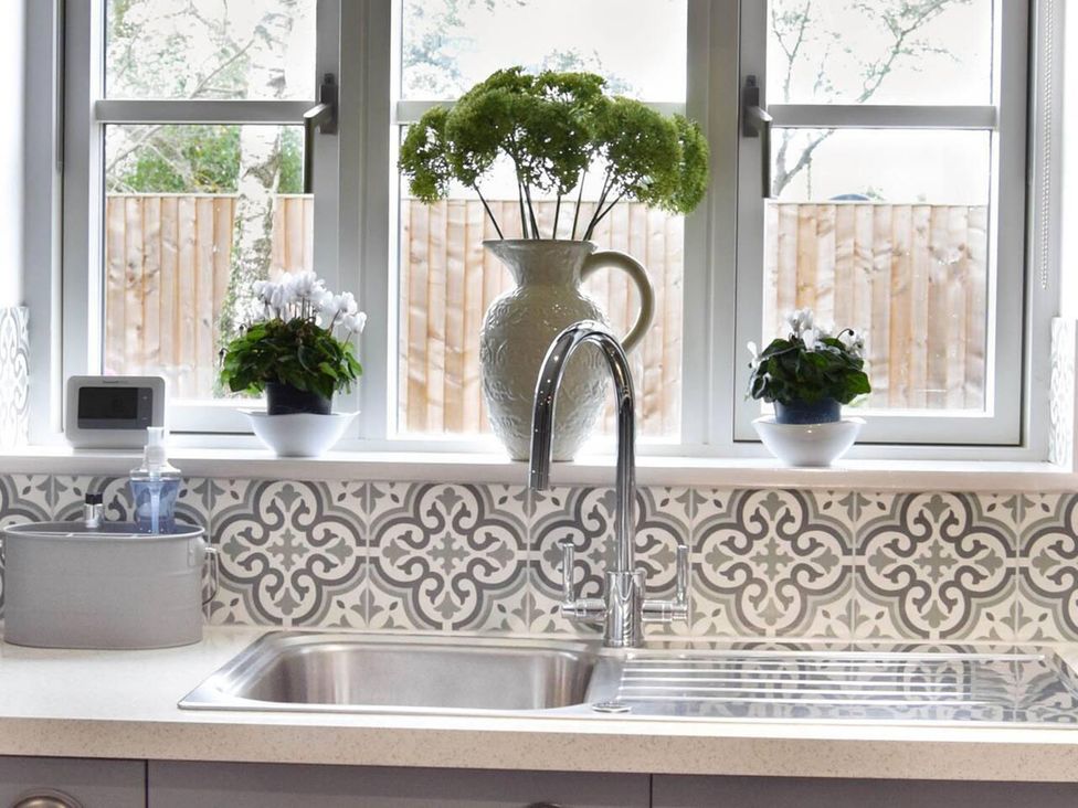 A kitchen sink with plants by the window at 1bed Pet Friendly nr Bicester village near Bicester