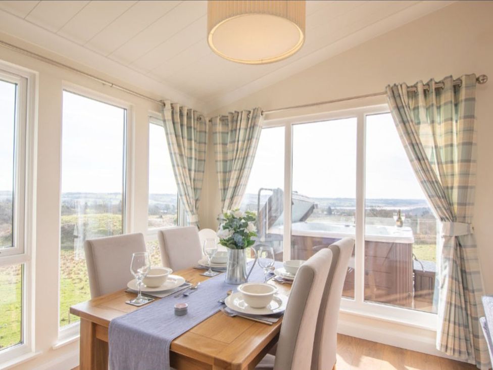A dining room with a table set for dinner at 2 Bedroom Sleeps 4 Lodge Smart Tv Hot tub Dogs Ok near Lochwinnoch