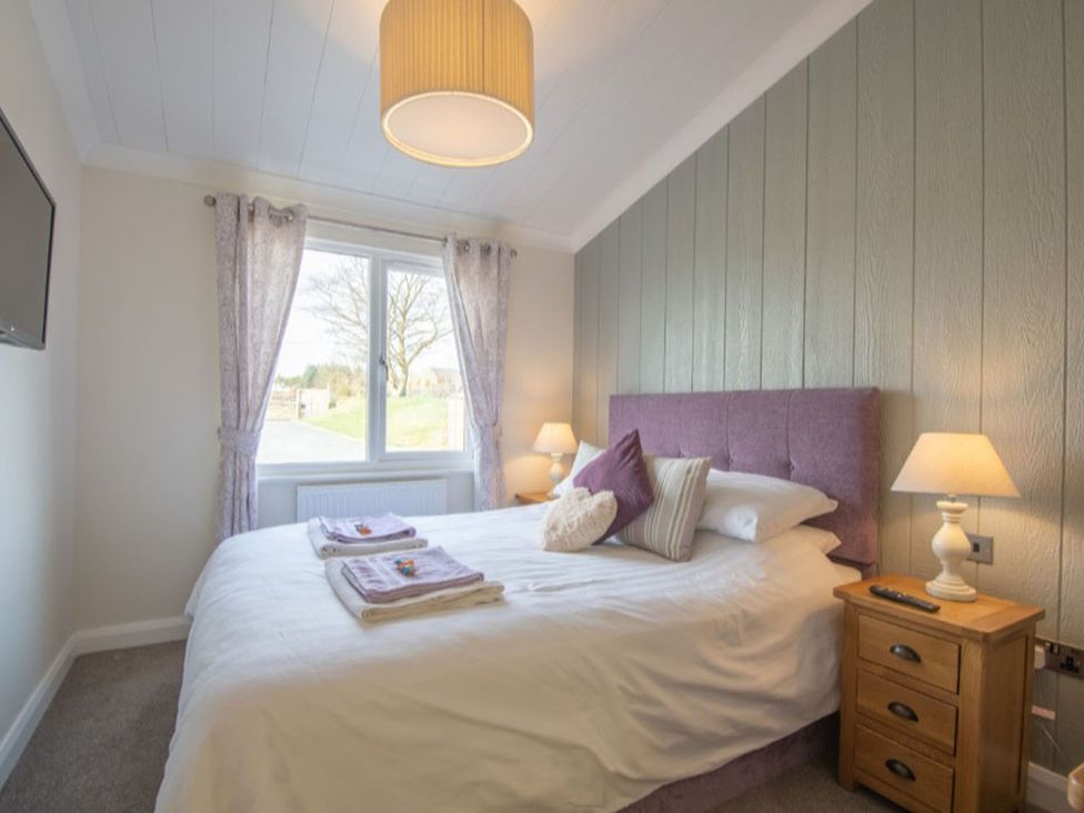 A bedroom with a bed and television at 2 Bedroom Sleeps 4 Lodge Smart Tv Hot tub Dogs Ok near Lochwinnoch